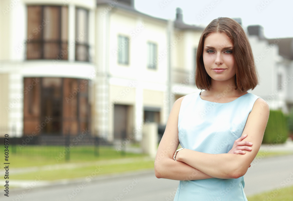 Young woman standing near house, isolated on white background