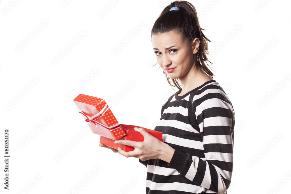 disappointed girl with questionable gesture holding a gift disappointed girl with questionable gesture holding a gift