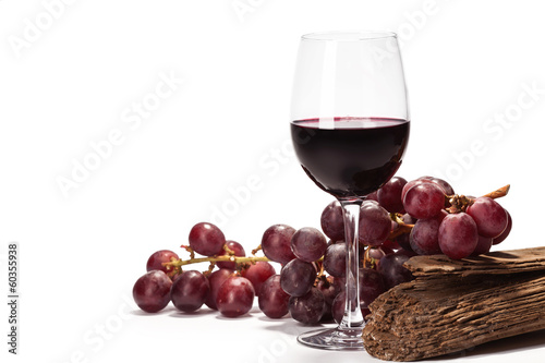 kieliszek czerwonego wina z winogronem na białym tle