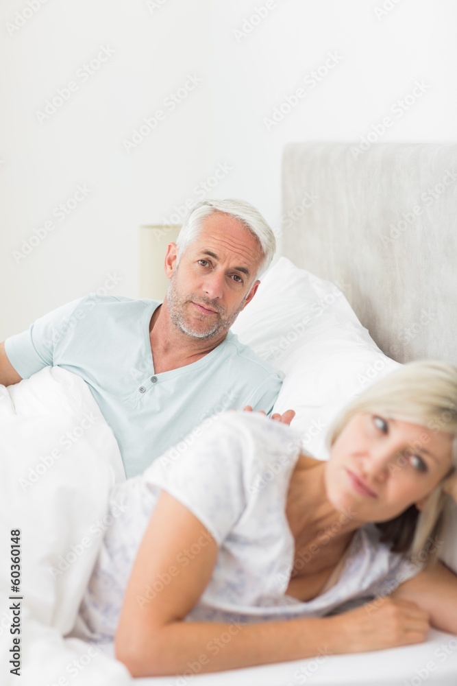 Woman besides man in bed at home