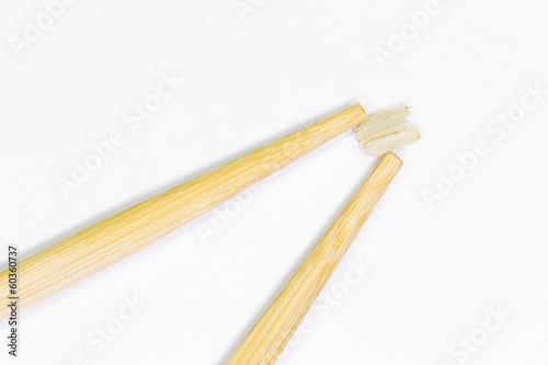 two wooden chopsticks for sushi and two grains of rice