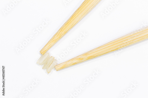 two sticks for sushi and three grains of rice