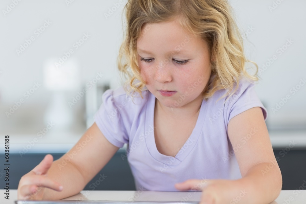 Girl using digital tablet at table Girl using digital tablet at table