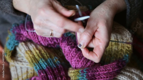 Woman hands knitting wool scarf, closeup video