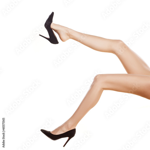 pretty female legs in black shoes with high heels on white