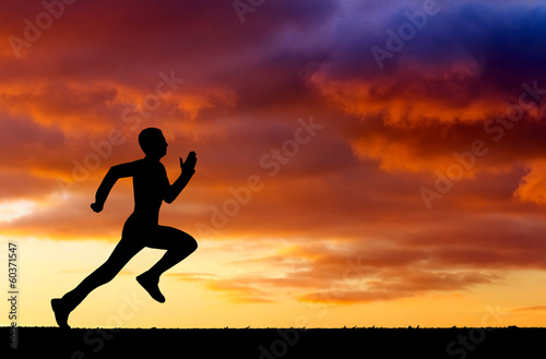 Silhouette of running man on sunset fiery background