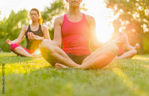 horizontal of a group of women doing yoga at sunset with flare