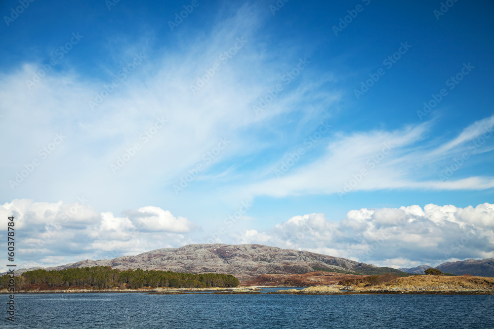 Empty Norwegian landscape. Blue sky with clouds over sea coast