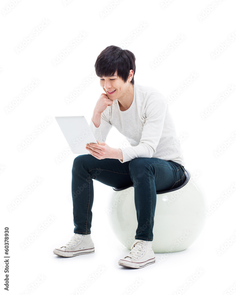 Young Asian man using a Pad PC isolated on white background. Young Asian man using a Pad PC isolated on white background.