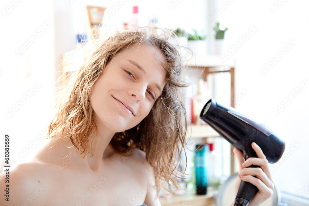 Young girl taking care of her hairs in a bathroom Young girl taking care of her hairs in a bathroom