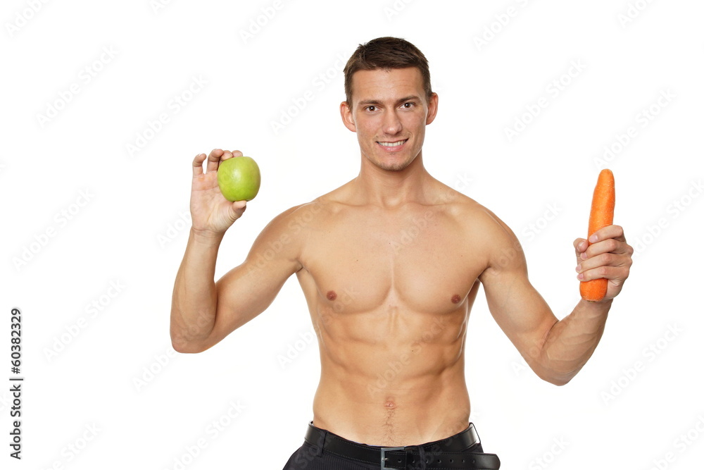 Young man holds in hands apple and carrot Young man holds in hands apple and carrot