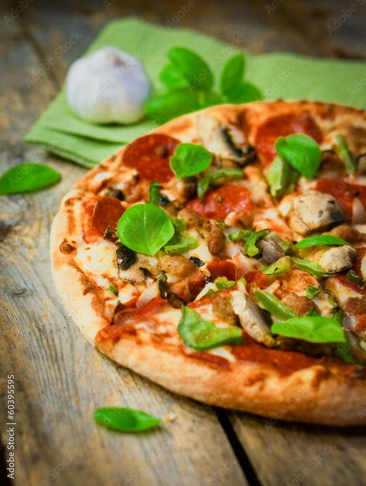 Sliced home made pepperoni pizza on wooden rustic background