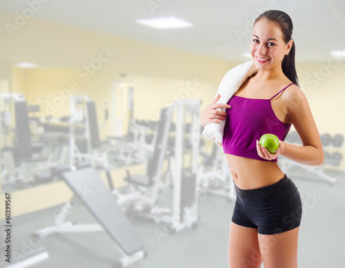 Sporty girl with apple at gym club © Boris Riaposov