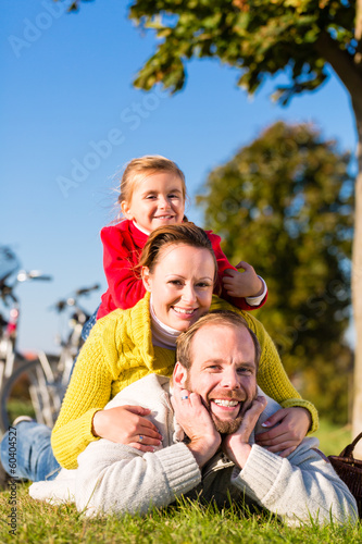Familie beim Ausflug mit dem Fahrrad im Park  © Kzenon