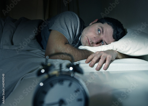 man in bed with eyes opened suffering insomnia sleep disorder photo