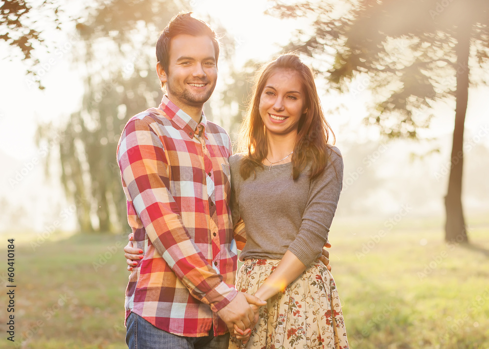 Young couple in love walking in the autumn park near the river. Young couple in love walking in the autumn park near the river.