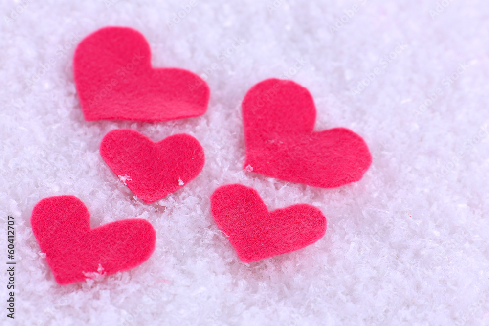 Obraz premium Little felt hearts on snowy background