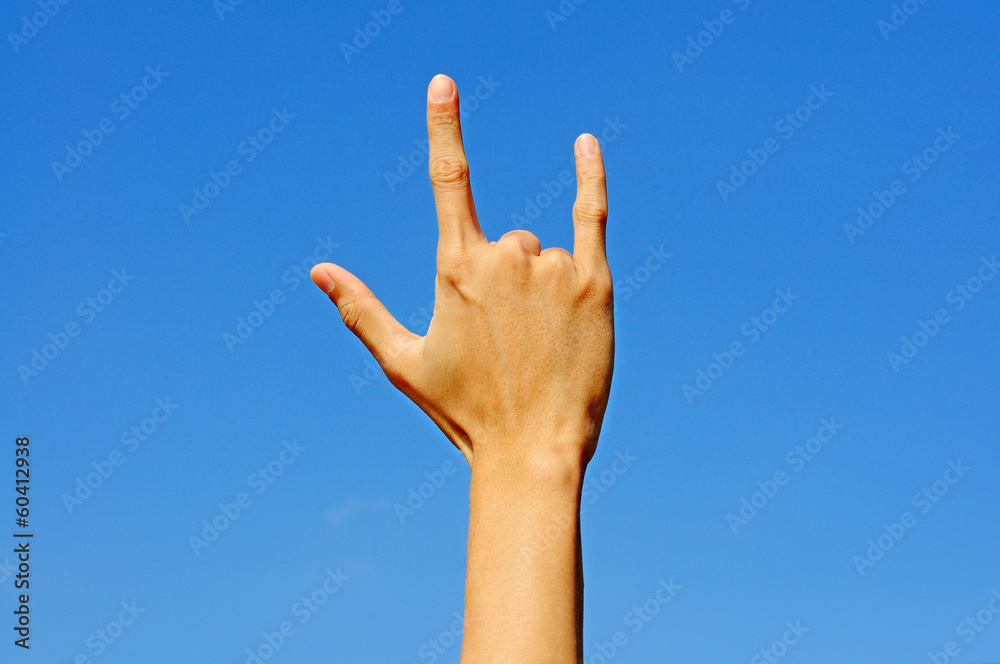 I love you in hand sign language on blue sky background. I love you in hand sign language on blue sky background.