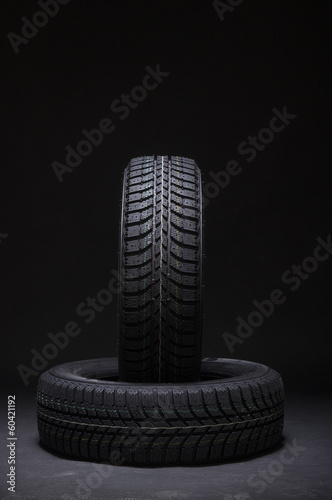 Vertical and horizontal winter tyres on black background