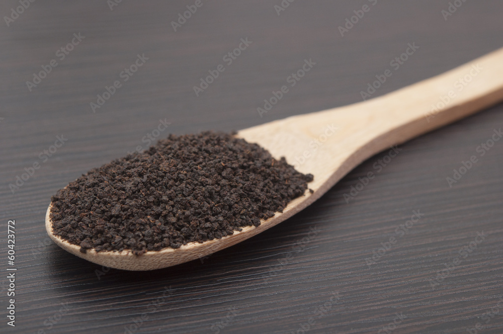 Bamboo spoon with black leaf tea Bamboo spoon with black leaf tea