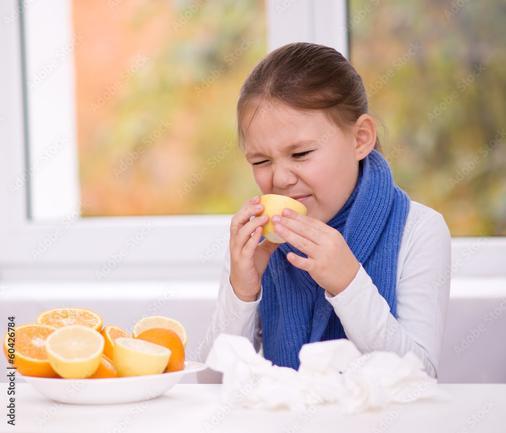 Girl tries to taste a slice of orange Girl tries to taste a slice of orange