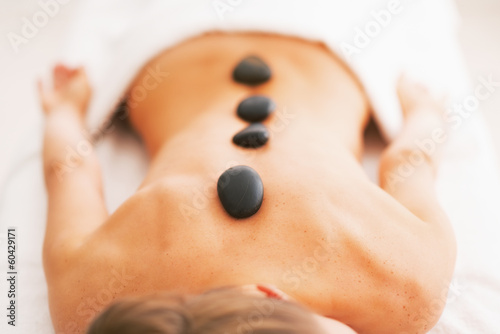 Closeup on young woman receiving hot stone massage