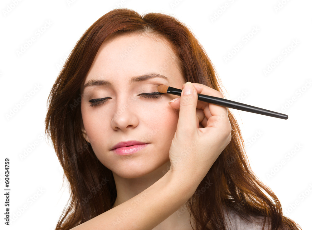 Stylist is applying eyeshadow for young girl Stylist is applying eyeshadow for young girl