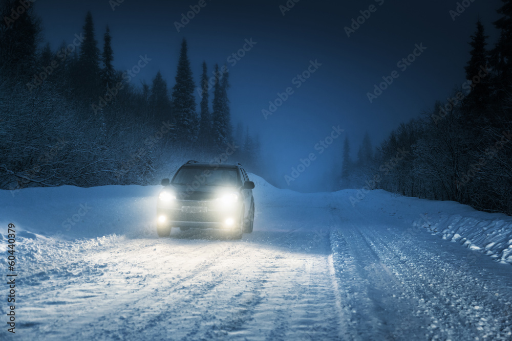 Fototapeta premium Car lights in winter Russian forest