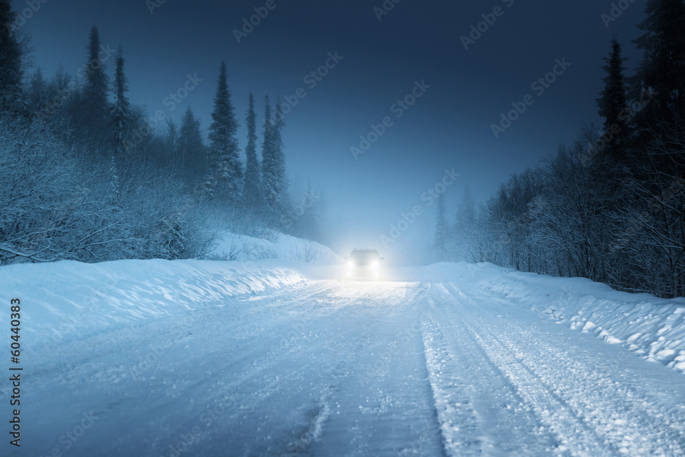 Fototapeta premium Car lights in winter Russian forest