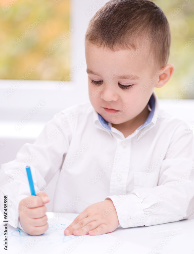 Little boy is drawing on white paper Little boy is drawing on white paper