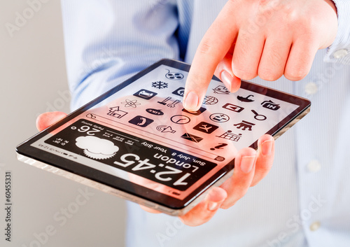 Tablet with transparent screen in human hands.