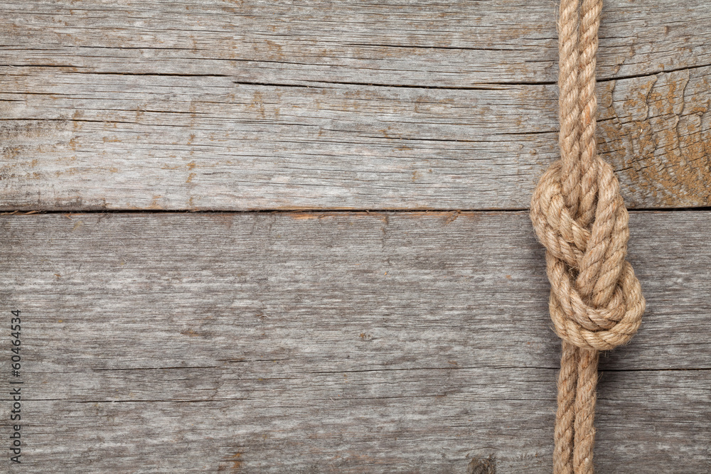 Ship rope knot on wooden texture background - obrazy, fototapety, plakaty 