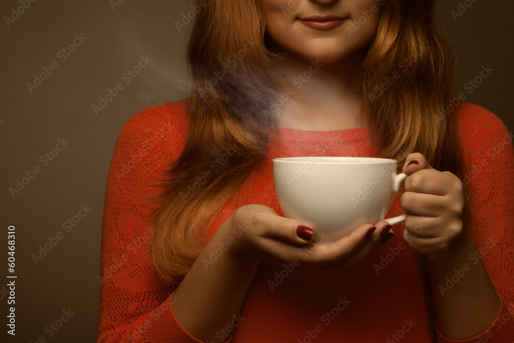 woman holding hot cup and smiles woman holding hot cup and smiles