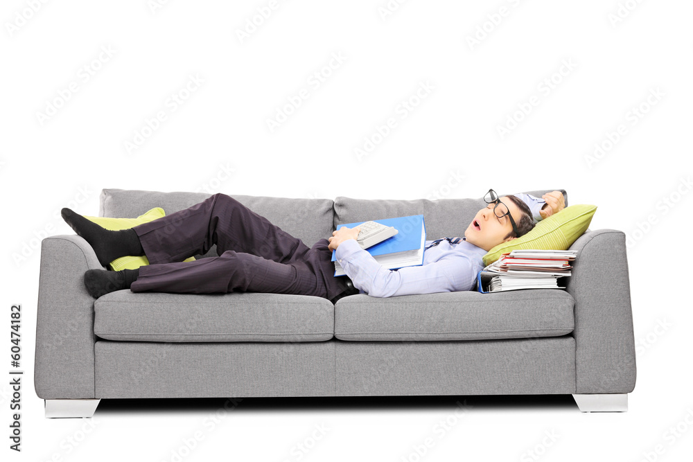 Exhausted young accountant sleeping on a couch Exhausted young accountant sleeping on a couch