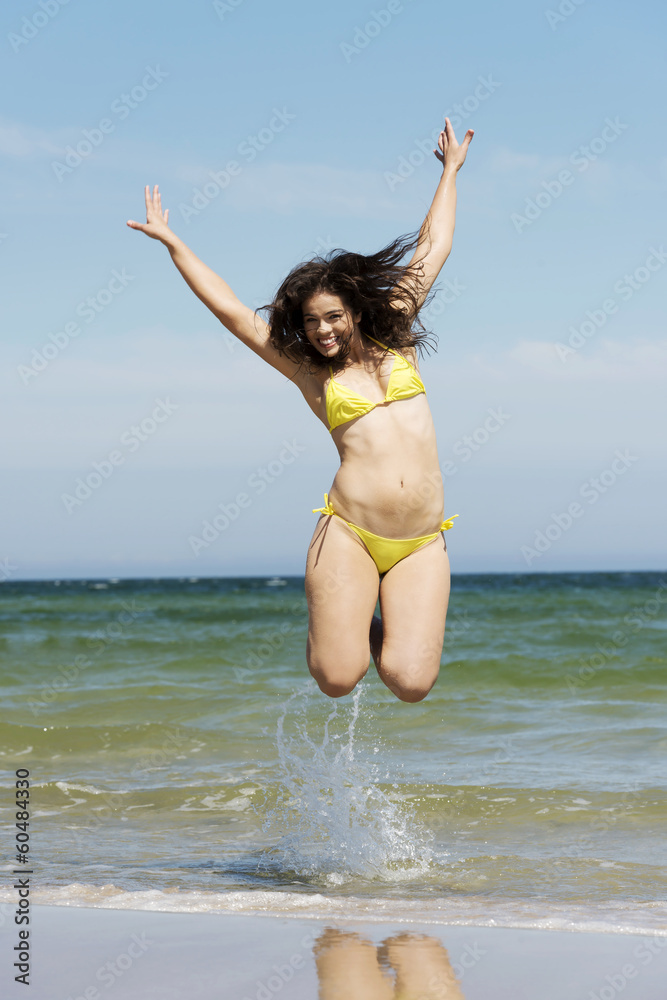 Beautiful summer woman in swimsuit jumping over seaside. Beautiful summer woman in swimsuit jumping over seaside.
