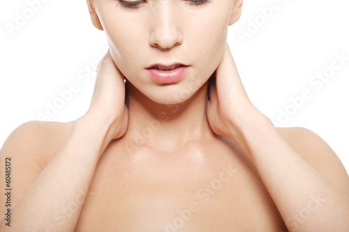 Naked woman touching her neck, head and shoulders close up.