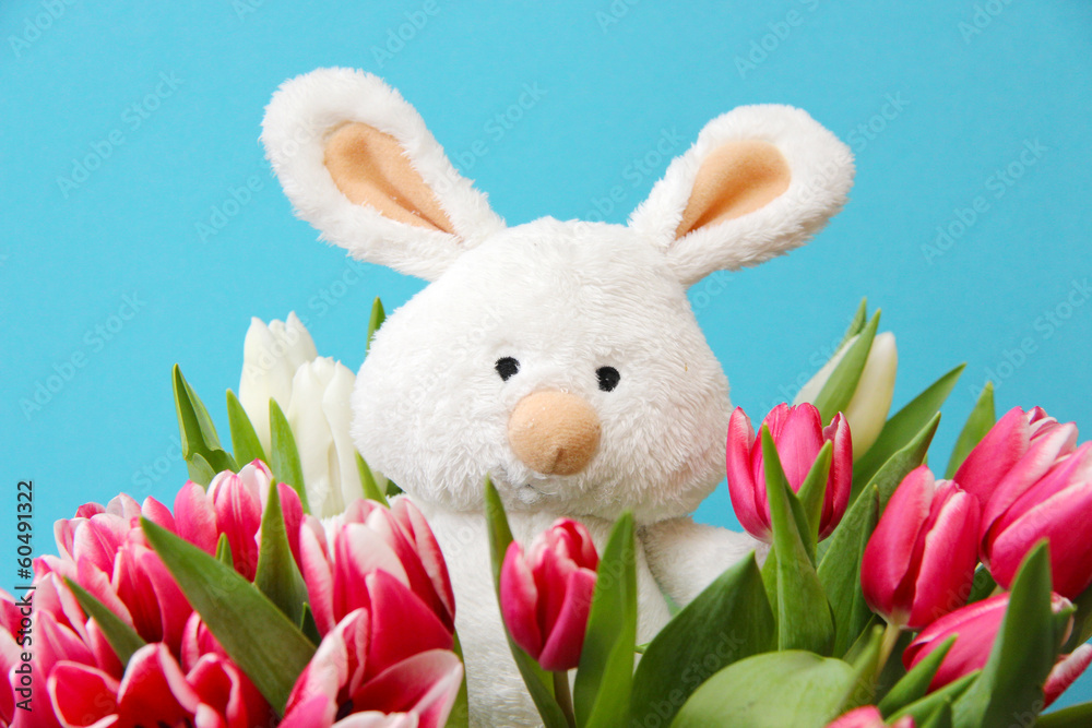 Osterhase mit Tulpen am blauen Hintergrund Osterhase mit Tulpen am blauen Hintergrund