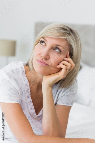 Tensed mature woman sitting in bed
