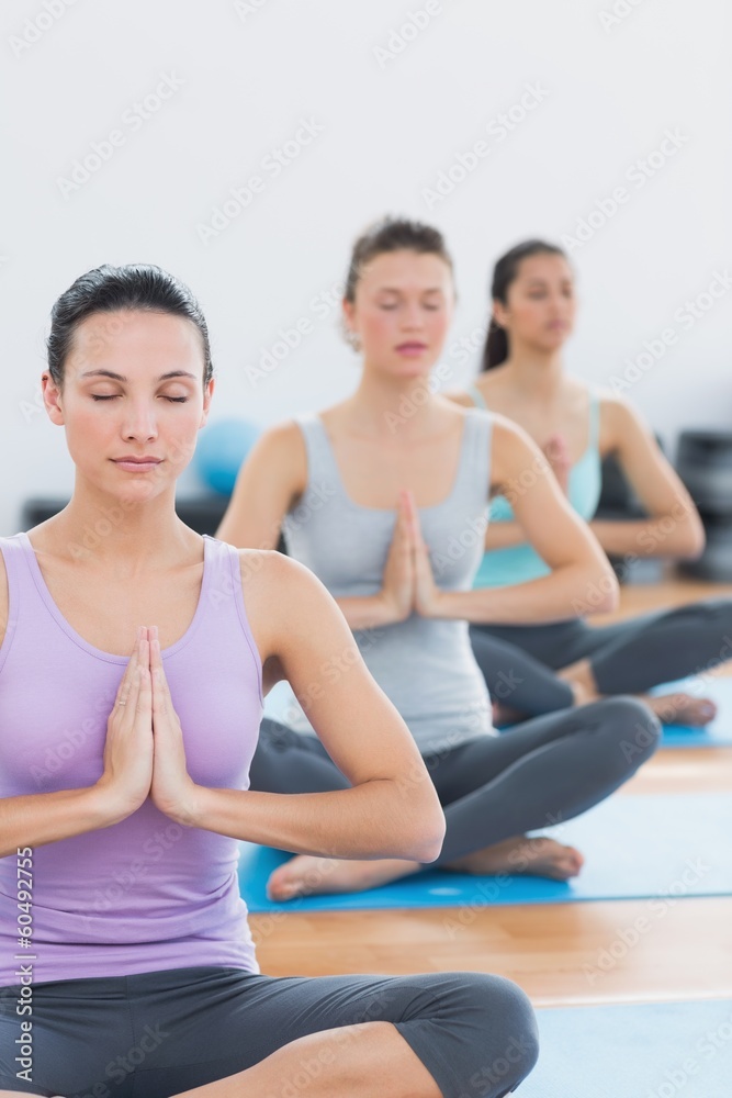 Women in Namaste position with eyes closed at fitness studio Women in Namaste position with eyes closed at fitness studio