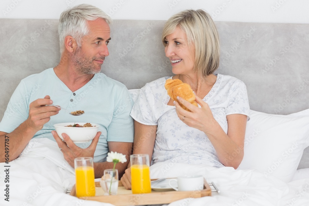 Happy couple having breakfast in bed Happy couple having breakfast in bed