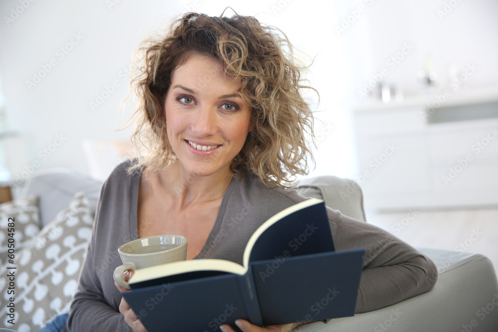 Woman reading book at home in sofa Woman reading book at home in sofa