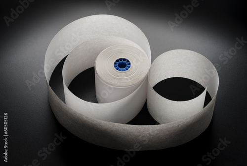 Roll of cash register paper tape on black photo