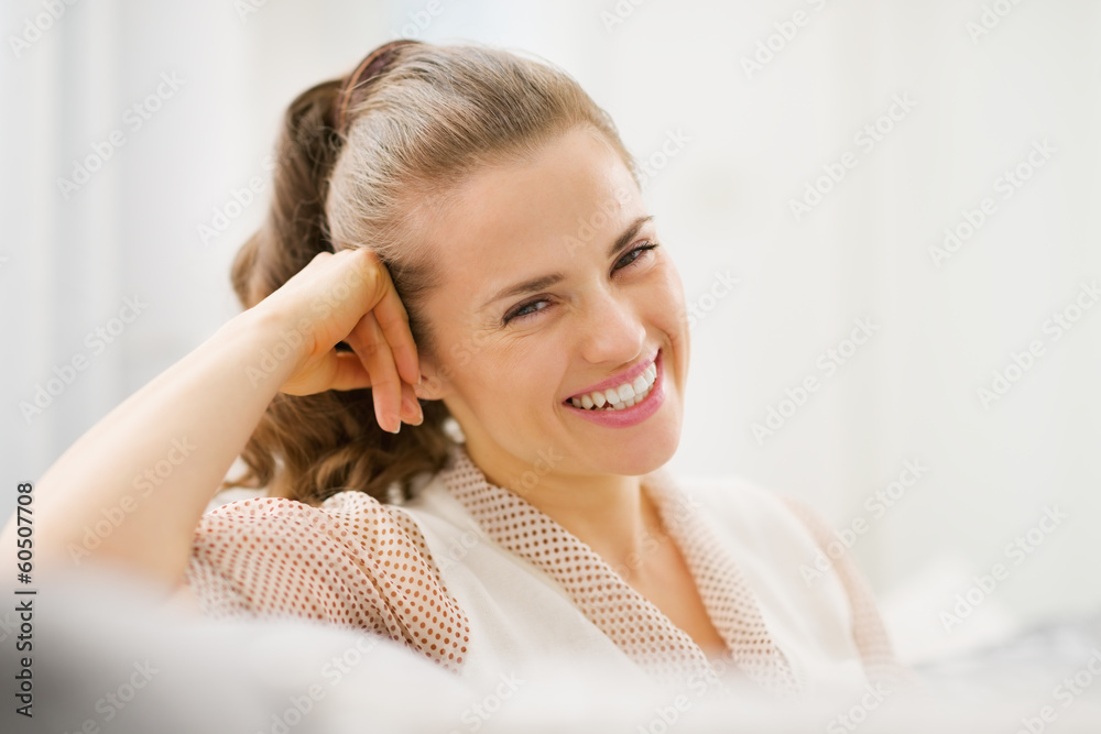 Portrait of smiling young housewife sitting on divan Portrait of smiling young housewife sitting on divan