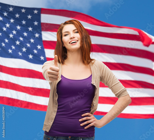 smiling girl in casual clothes showing thumbs up photo