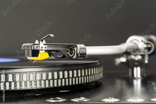 Phonograph cartridge waits over turntable photo