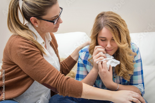 Obraz na plátně Mother soothes sad teen daughter crying