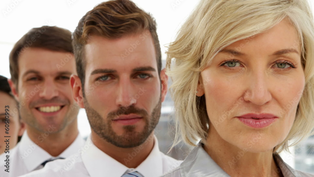 Business team standing in a row looking at camera Business team standing in a row looking at camera