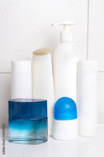 set of white cosmetic bottles over tiled wall