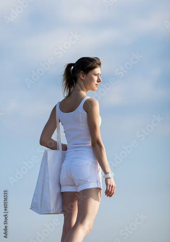 Attractive girl with white bag on open air
