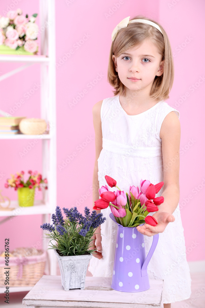 Beautiful little girl and stand with flowers on pink background Beautiful little girl and stand with flowers on pink background